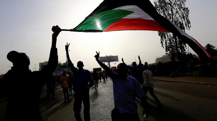 sudanese_demonstrators_wave_their_national_flag_as_they_arrive_for_a_protest_rally_outside_the_defense_ministry_in_khartoum_sudan_april_11_2019._reuters.jpg