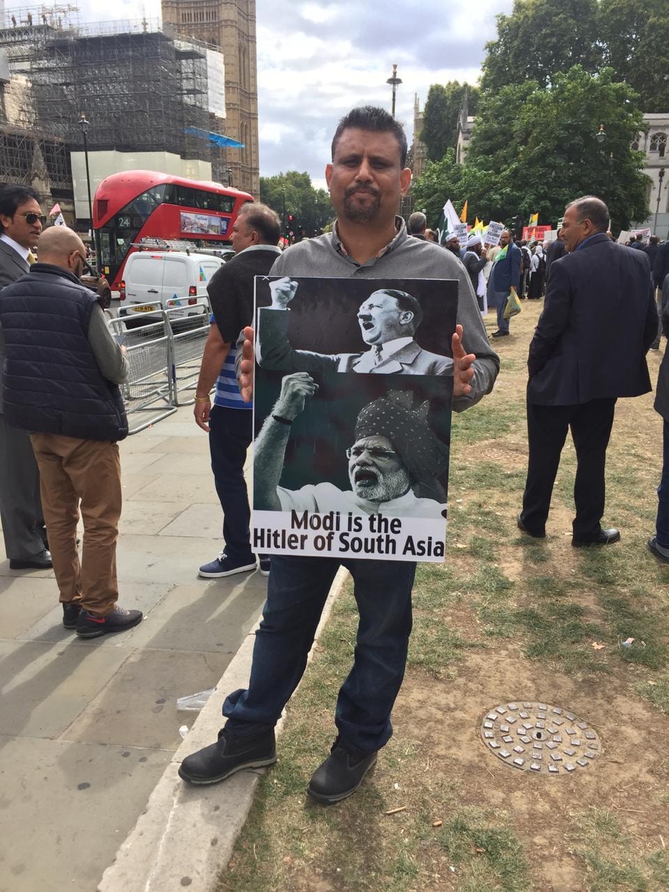 A protester carries a placard inscribed with a slogan equating Modi with Hitler. — Photo by Atika Rehman