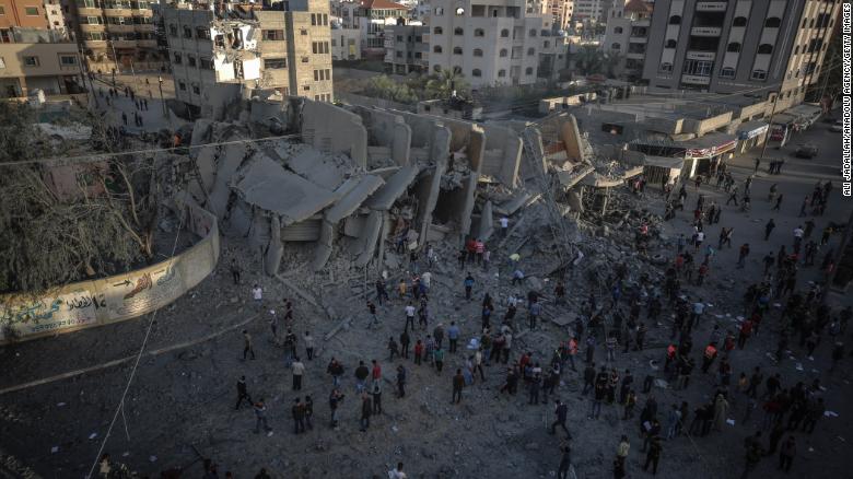 Palestinians inspect the remnants of the Abo Kamar building after airstrikes carried out by Israeli warplanes in Gaza City, Gaza, on Sunday