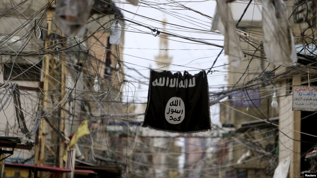 FILE - An Islamic State flag hangs amid electric wires over a street in Ain al-Hilweh Palestinian refugee camp, near the port-city of Sidon, southern Lebanon Jan. 19, 2016.