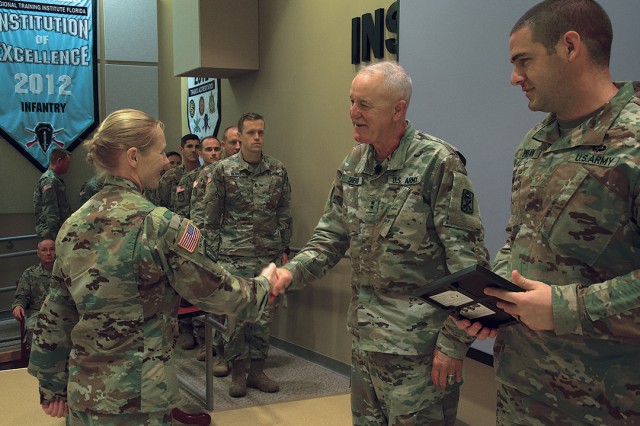 Maj. Gen. Timothy Sheriff, Commander of the 263rd Army Air and Missile Defense Command hands graduation certificates to the 12 Soldiers of the 164th Air Defense Artillery Brigade who completed the Patriot Training Program, designed to teach Army National Guard air defenders how to properly integrate systems such as Patriot Surface to Air Missiles and THAAD (Terminal High Altitude Area Defense) within their commands, during a ceremony at Camp Blanding Joint Training Center.