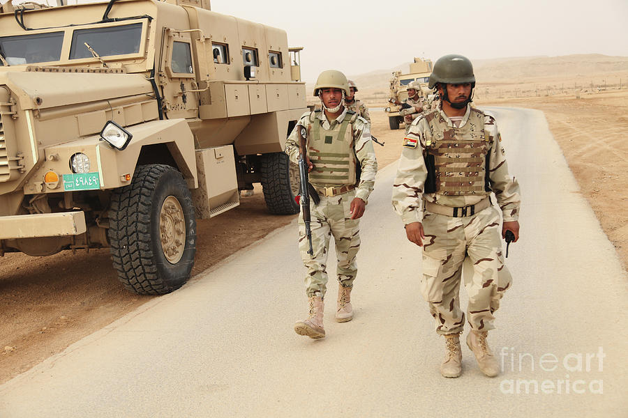 iraqi-army-soldiers-walk-beside-an-mrap-stocktrek-images.jpg
