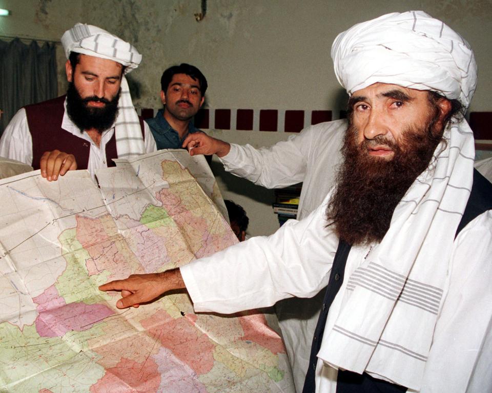 FILE: Jalaluddin Haqqani (R), the Taliban's Minister for Tribal Affairs, points to a map of Afghanistan during a visit to Islamabad, Pakistan