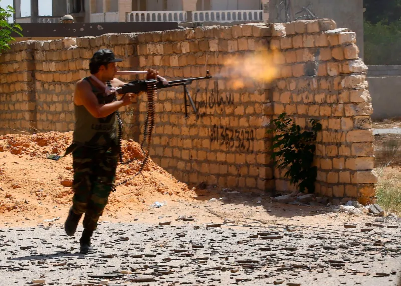 A fighter loyal to the internationally recognized Libyan Government of National Accord fires his gun during clashes with forces loyal to strongman Khalifa Haftar in Tripoli on Sept. 7.