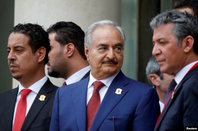 Khalifa Haftar, center, the military commander who dominates eastern Libya, leaves after an international conference on Libya at the Elysee Palace in Paris, May 29, 2018.