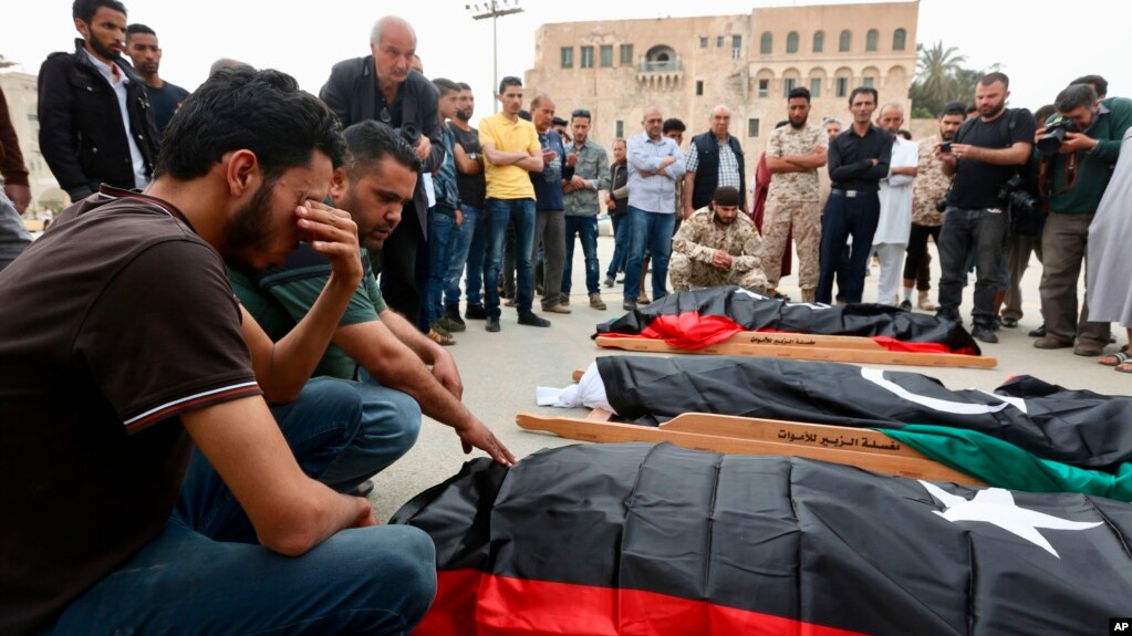 FILE - Mourners gather for funeral prayers for fighters killed by warplanes of Field Marshal Khalifa Hifter's forces, April 24, 2019, in Tripoli, Libya. 
