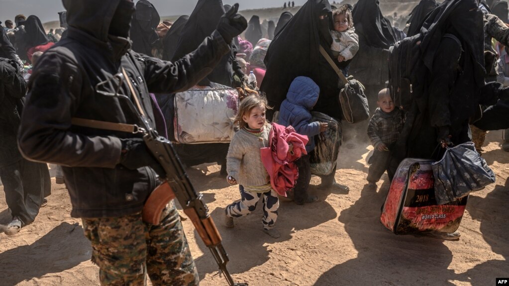 FILE - Women and children evacuated from the Islamic State group's holdout of Baghuz arrive at a screening area held by the U.S.-backed Syrian Democratic Forces, in the eastern Syrian province of Deir el-Zour, March 6, 2019.